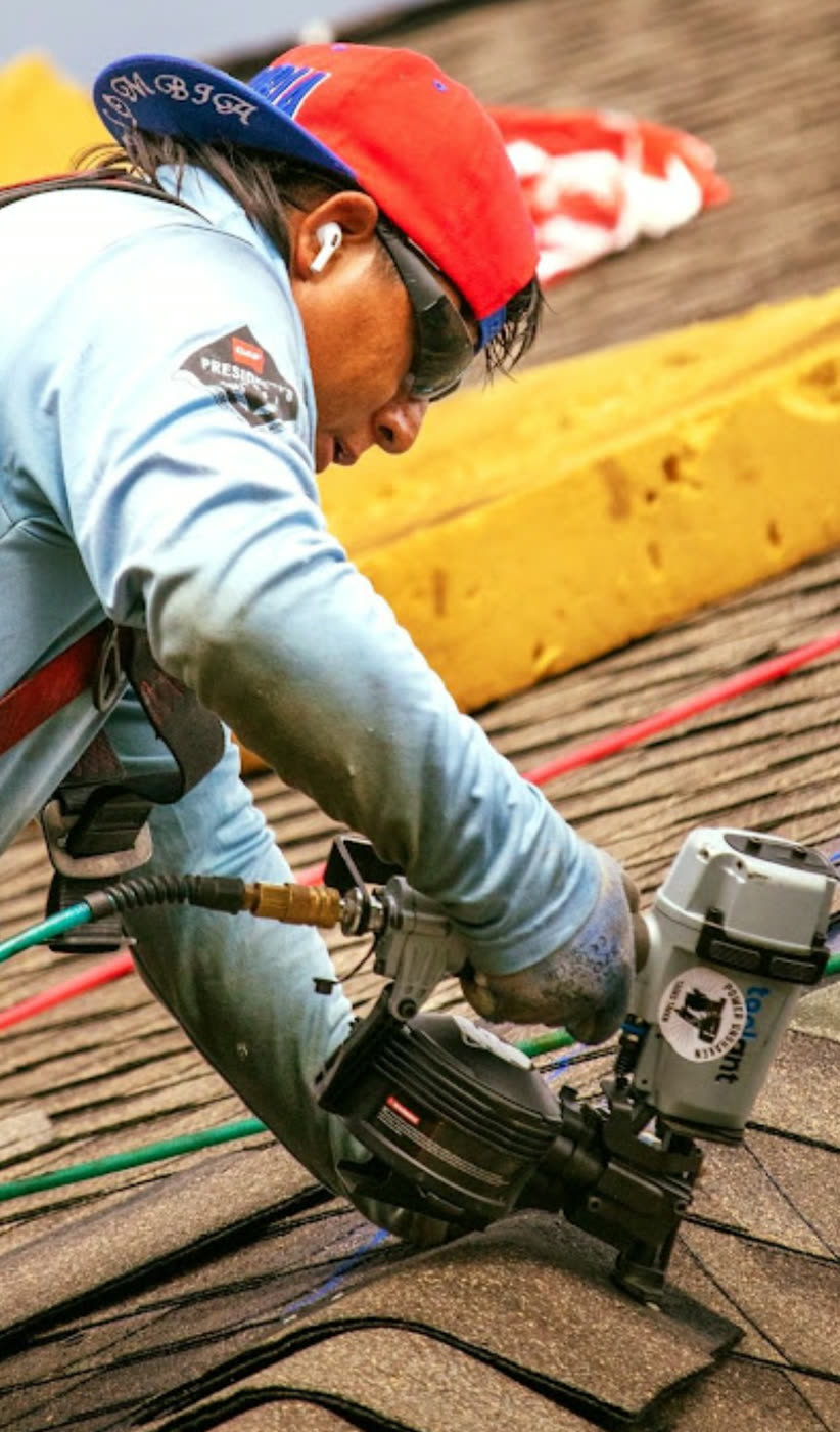 Close-up of shingles being fastened along a roof course